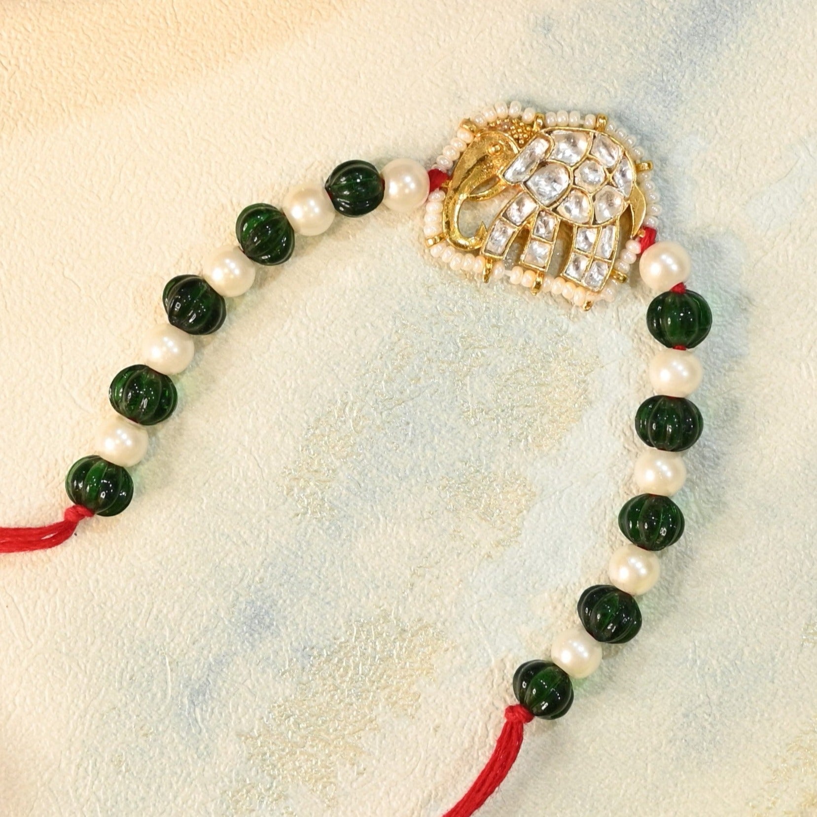 SJRB1015- White and Green Colour Gold Plated Jadau Kundan Elephant Motif Rakhi
